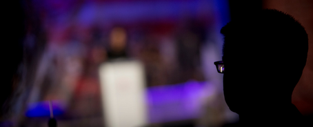 A man watching a speaker from the Remember America Speaker Series