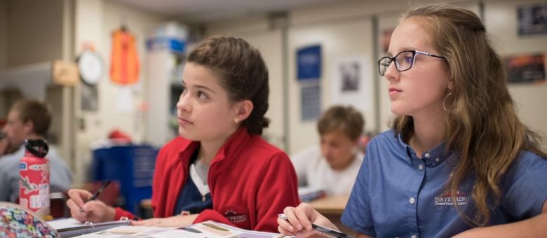 two middle school girls take note in class at dayspring christian academy.