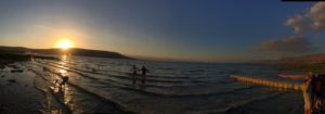 Students. teachers, and alumni of Dayspring watch the sun set at the sea of galilee.