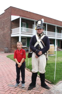 A Dayspring student stands with a soldier at Fort McHenry.