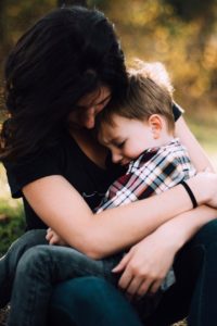 A vigilant mother hugs her child.