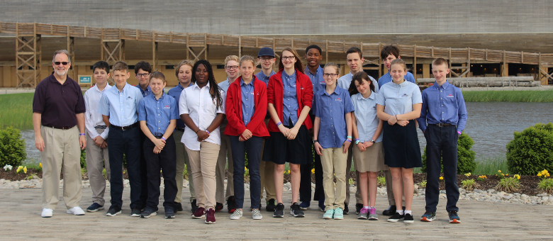 Dayspring 7th grade students stand with their teacher in front of the Ark Encounter.