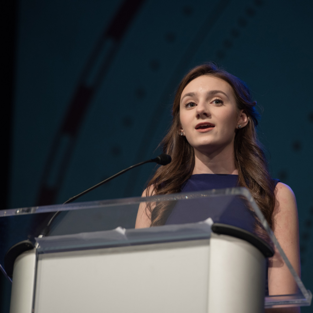 A female Dayspring Christian Academy student speaking at a podium