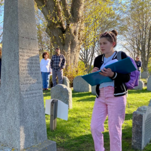 A young lady stands at William Bradford's tomb in Plymouth, Massachusetts.