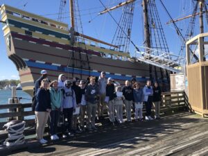 High school students stand in front of the Mayflower II in Plymouth, Massachusetts